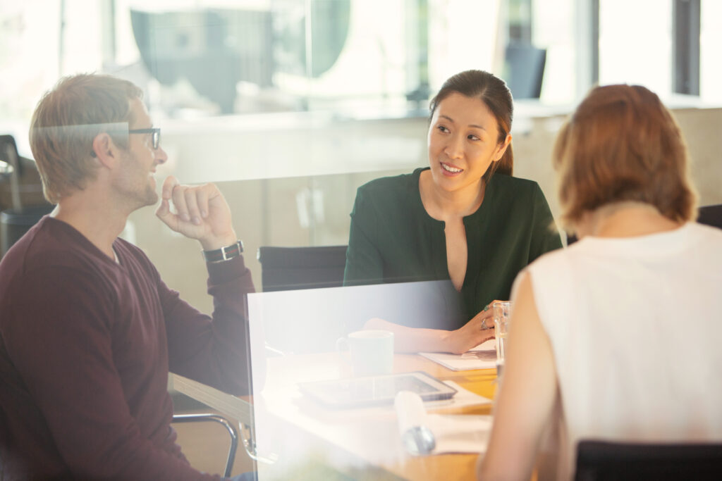 Three people in a meeting listening closely to each other.